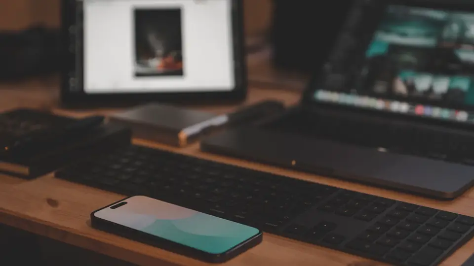 Phone, laptop and tablet on a wooden desk