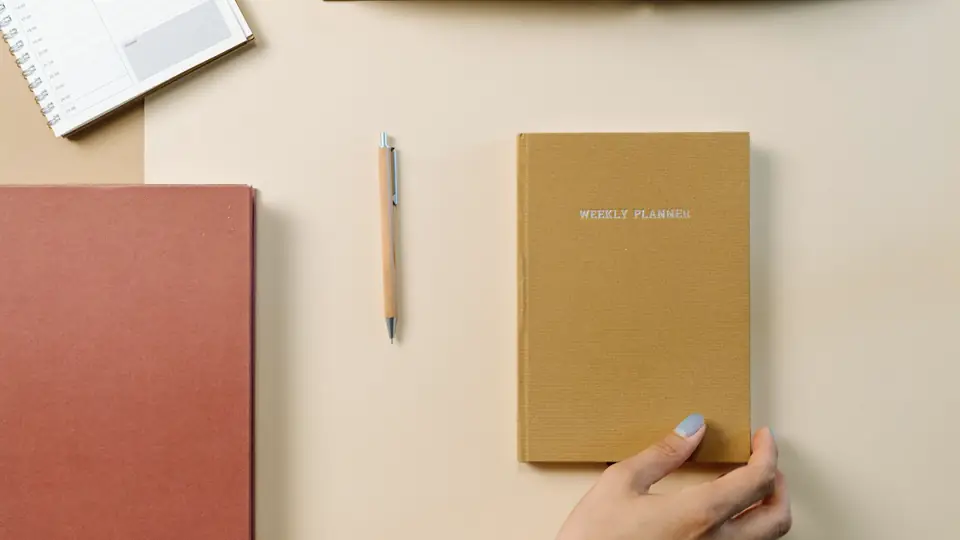 Two notebooks and a pencil on a light desk