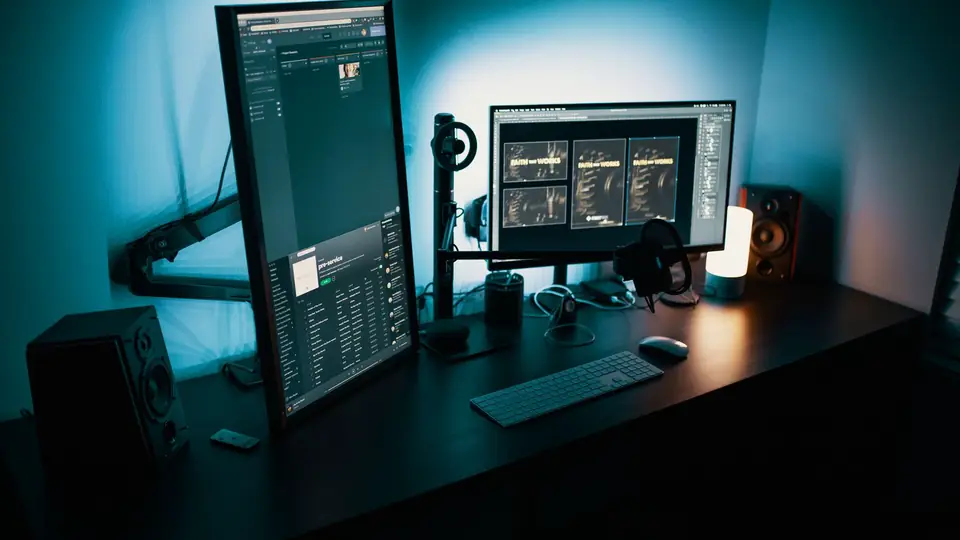 Schreibtisch mit zwei Monitoren und Tastatur